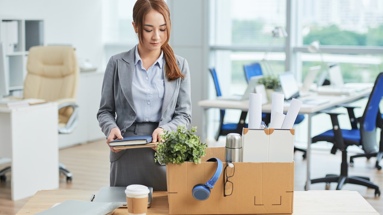 woman packing a box of office equipment