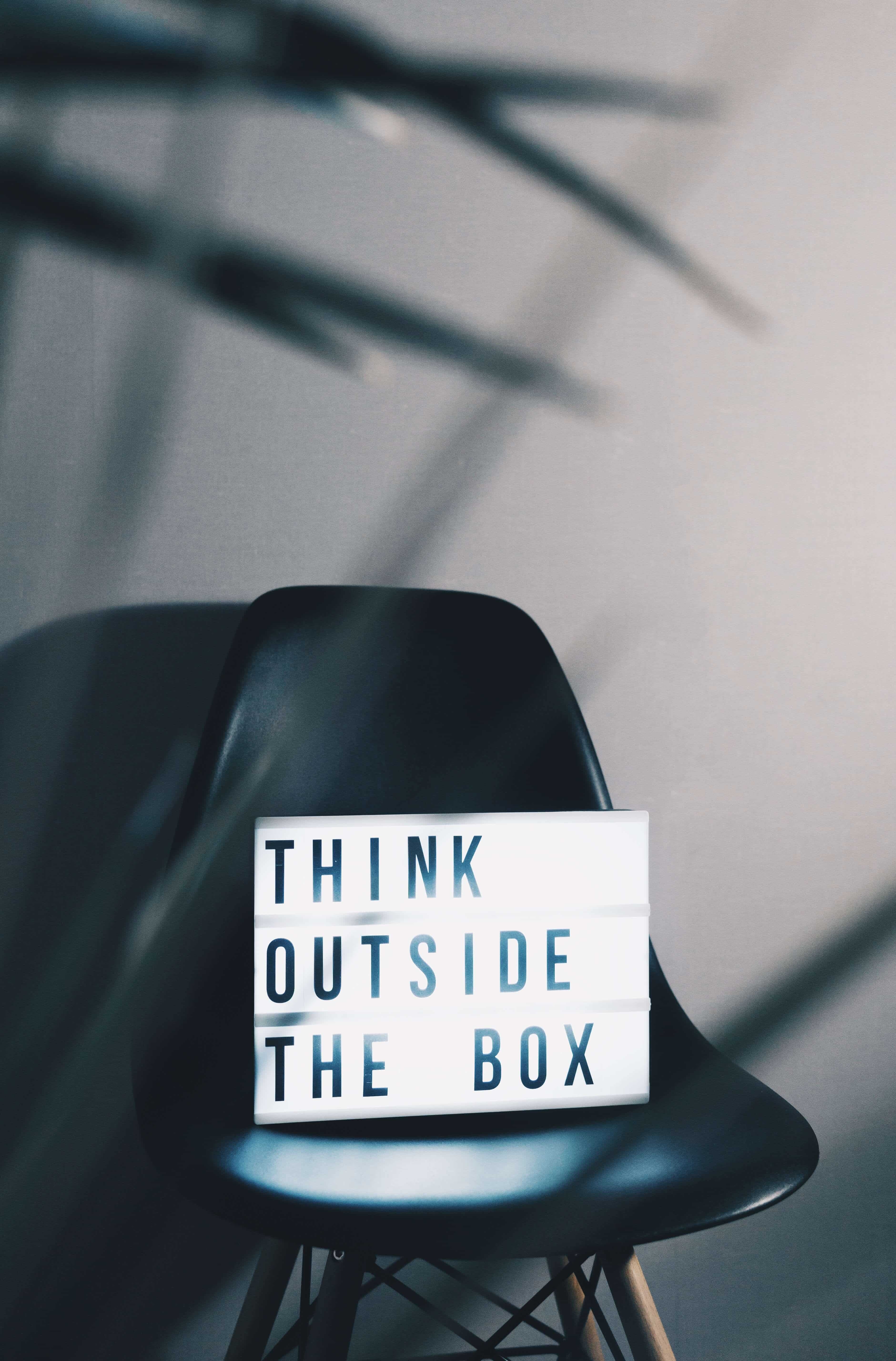 Think outside the box light box on a black chair