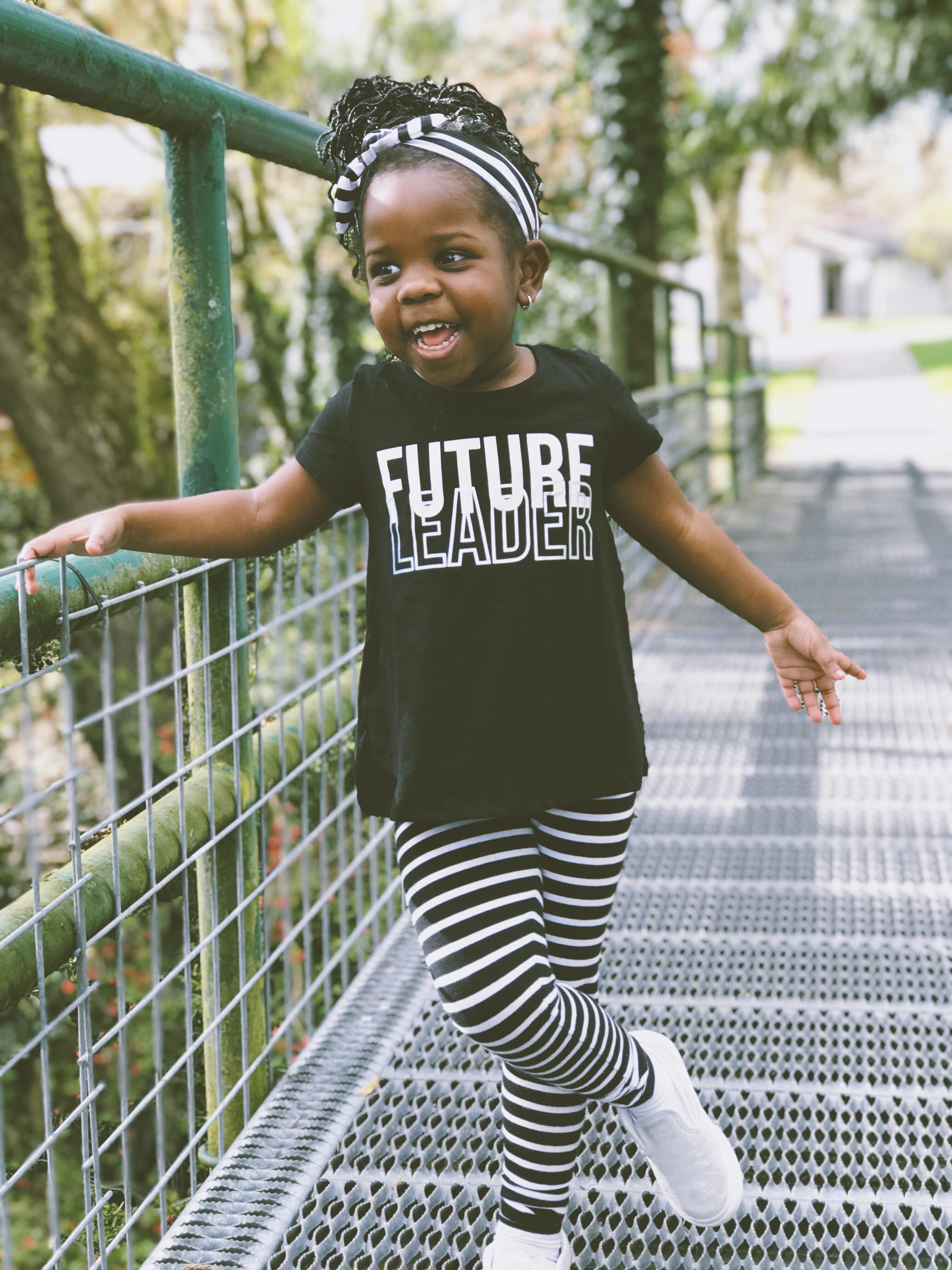A little girl wearing a t-shirt saying "future leader"