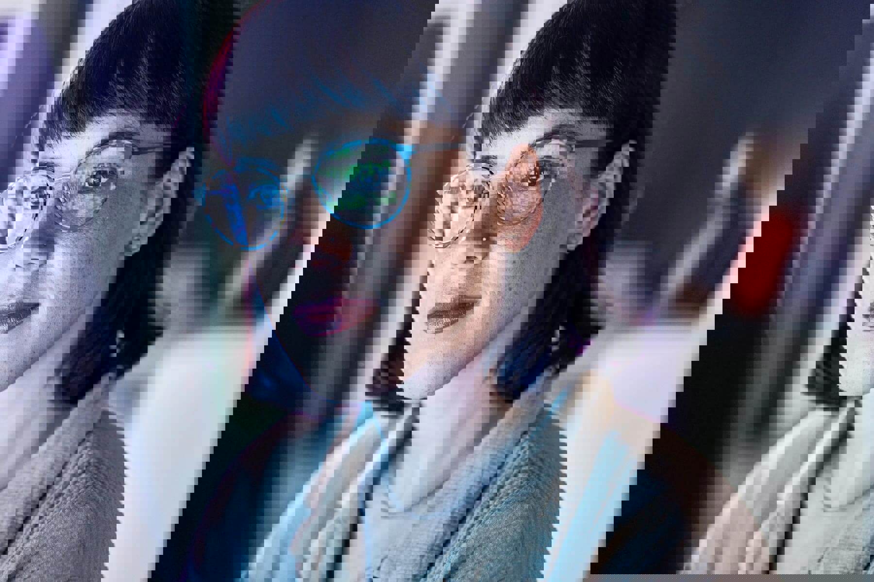 Business woman face, computer and UX coding of young employee with blue light and glasses. Digital code, hacker face and reading of a female worker at night planning with online cybersecurity data