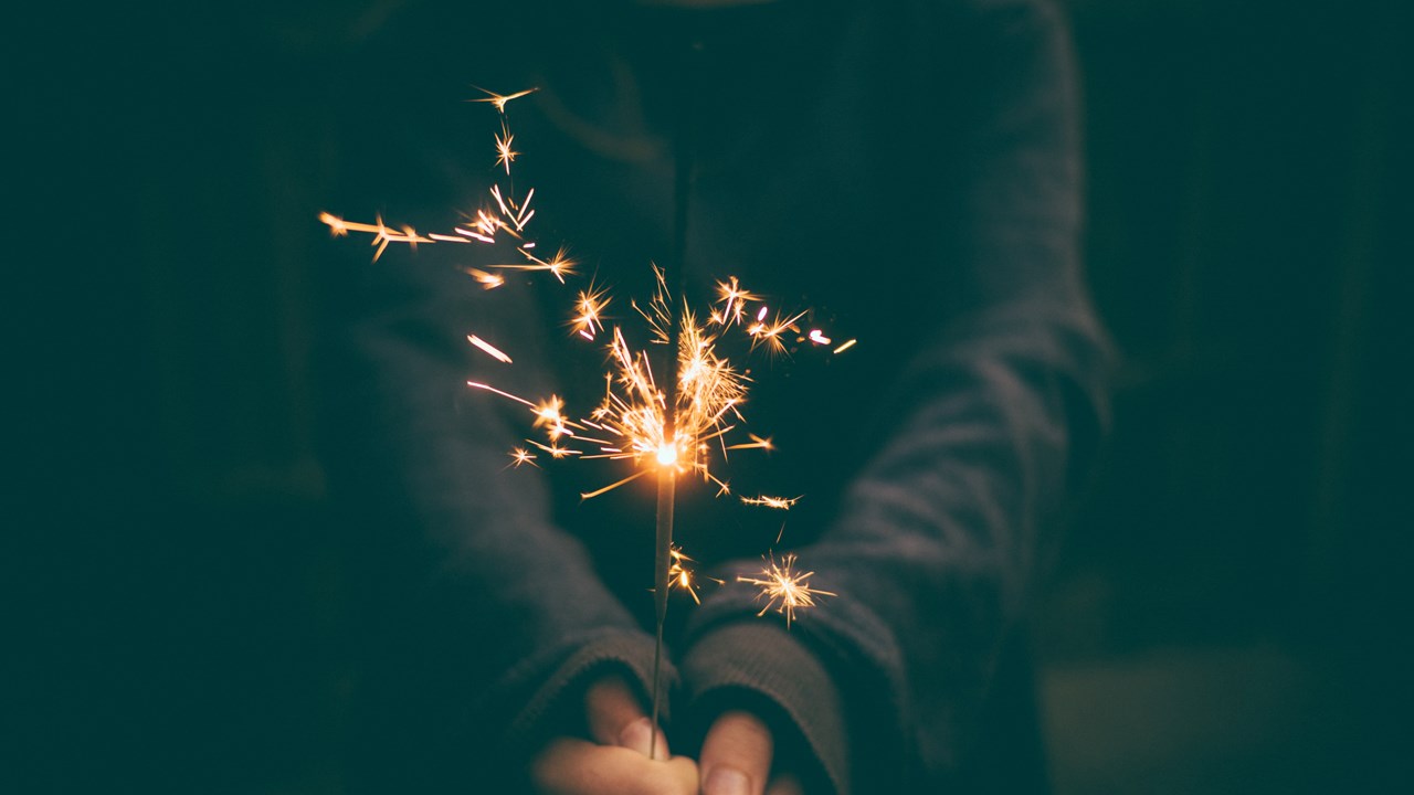 A woman holding a sparkler in the dark