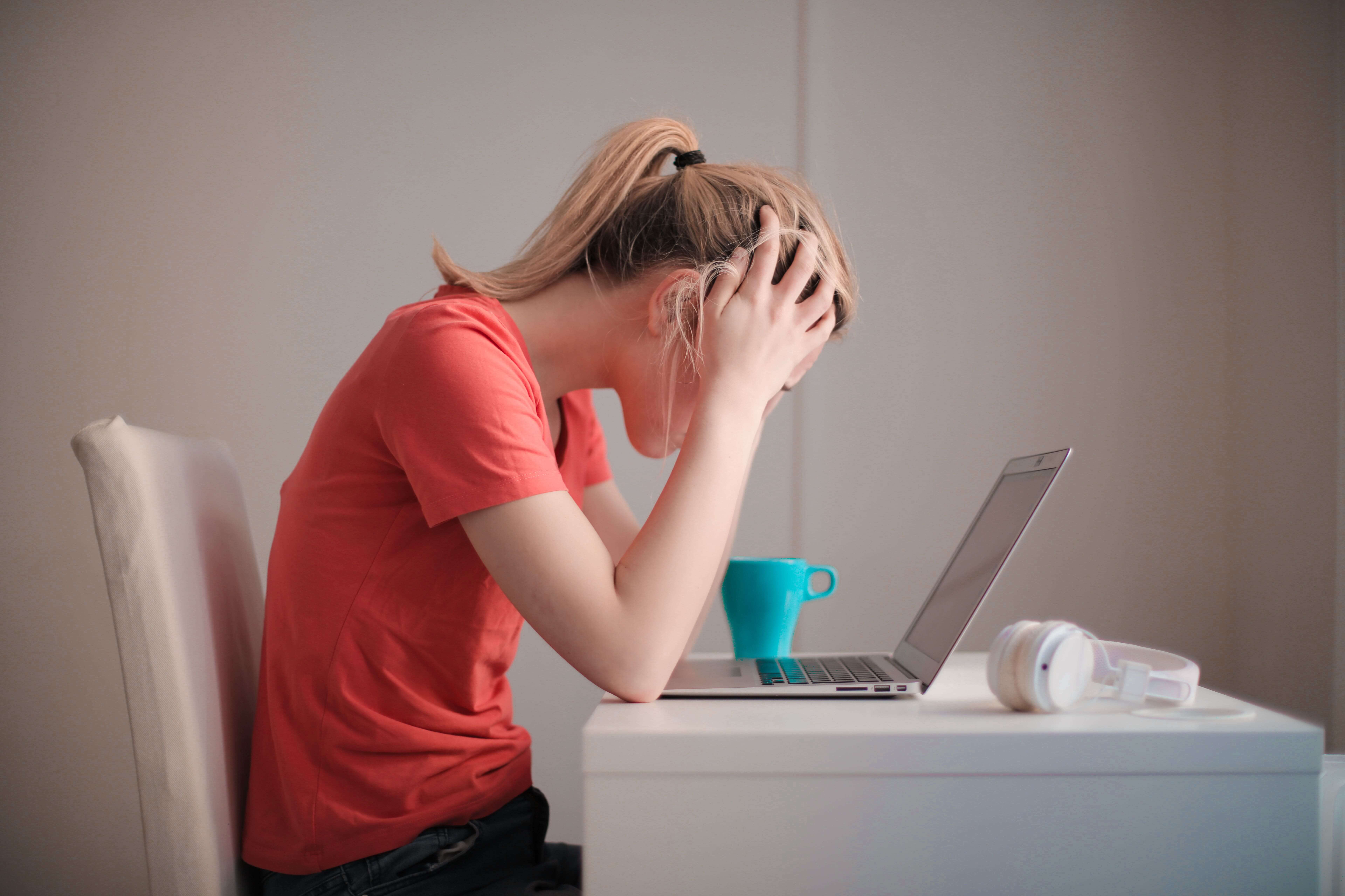 A woman stressed in front of a laptop