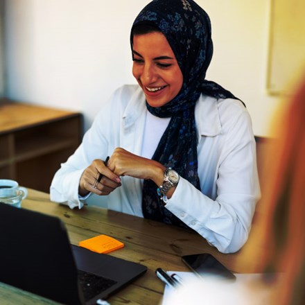 Happy middle eastern businesswoman with headscarf having video call with laptop.
